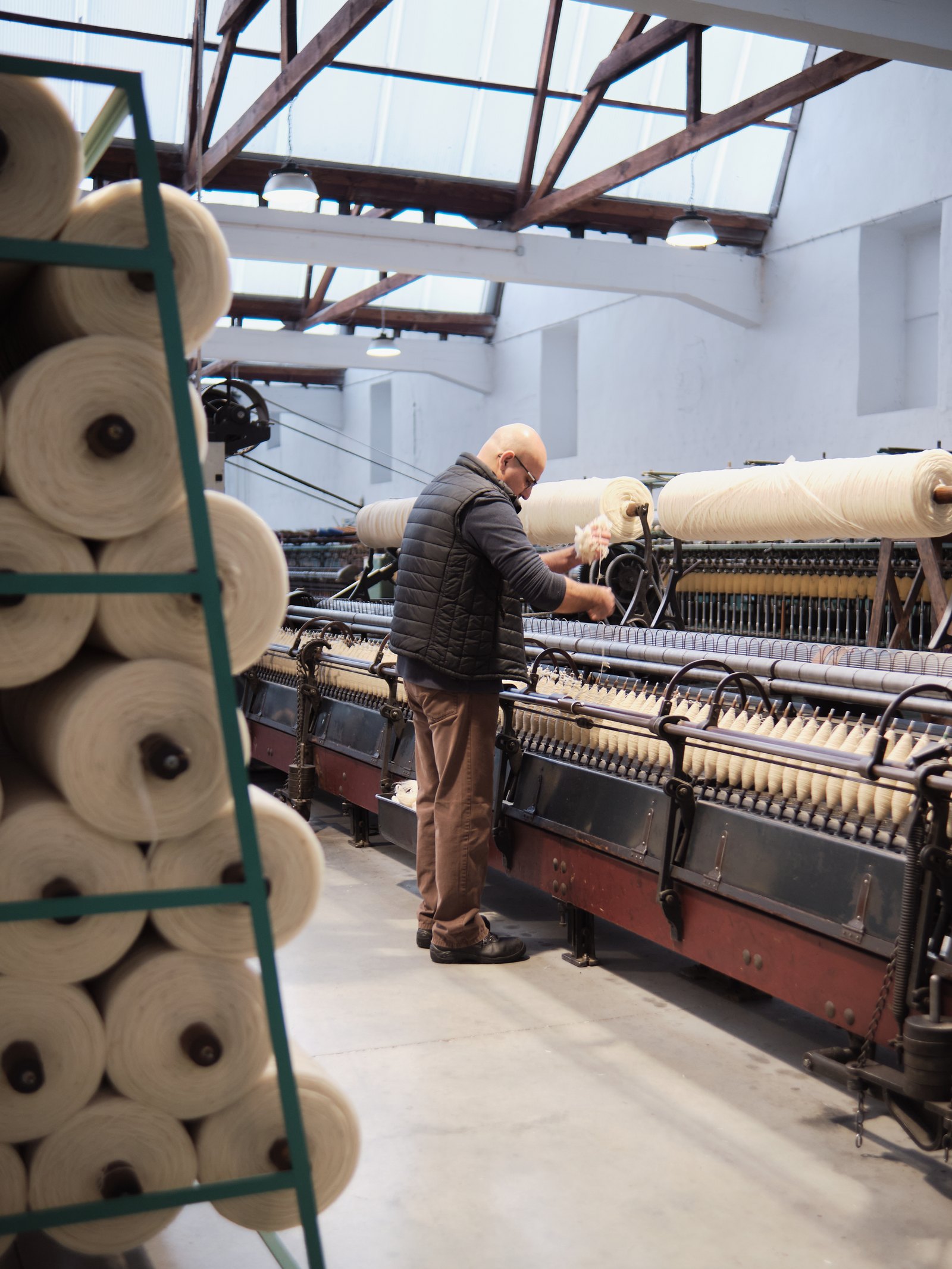 Large spools of yarn are divided into smaller spools. Photo taken at Burel Factory