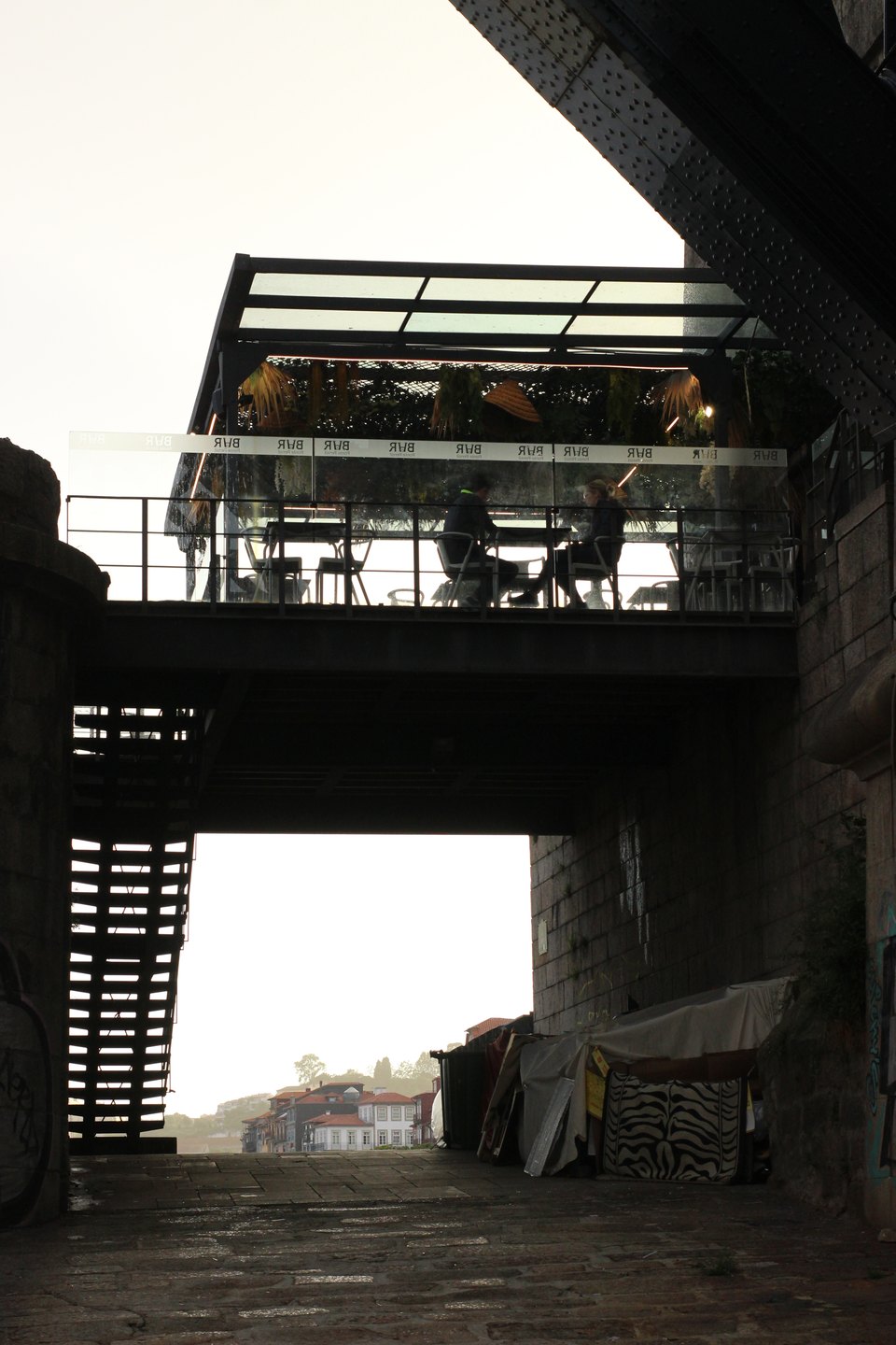 This might be one of Porto’s most iconic spots, a magnet for photographers capturing endless reflections, misty atmospheres, and abstract compositions. But just next to Luís I bridge, beneath the touristy bar perched above, someone is facing the harsh reality of the housing crisis—hidden in plain sight. 🇵🇹 Luís I Bridge, Porto