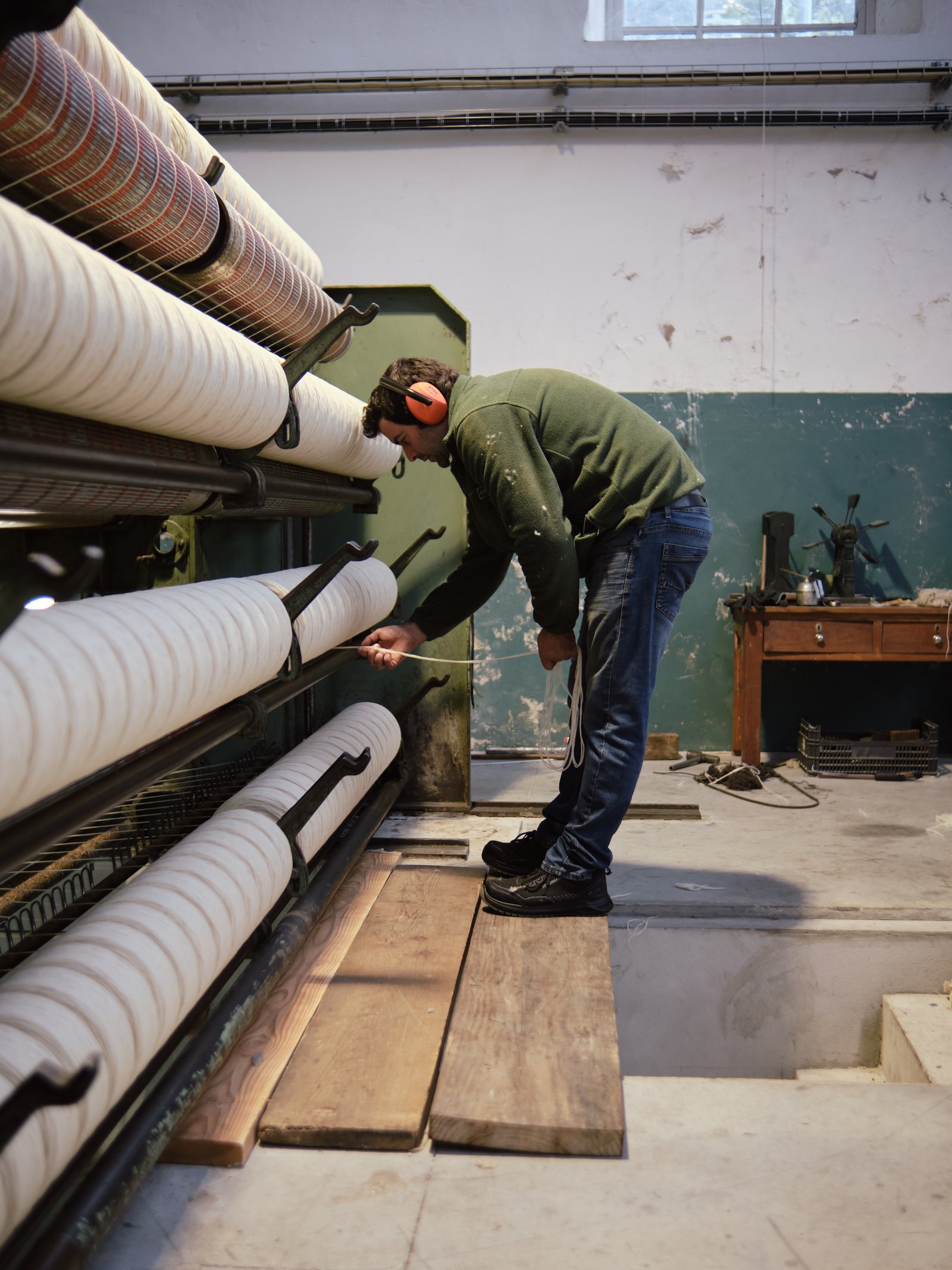 The raw wool ends up reeled at the end of the machine and the worker checks it's quality Photo taken at Burel Factory