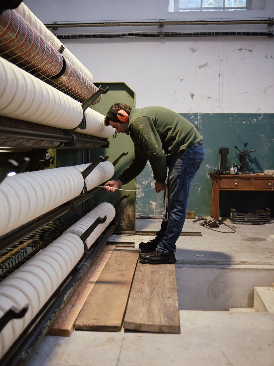 The raw wool ends up reeled at the end of the machine and the worker checks it's quality Photo taken at Burel Factory